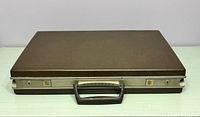 Closed attaché case showing top, latches and handle