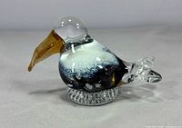 Full side view of glass toucan on clear base