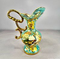 Front view showing peacock motif, floral decoration, gilt handle