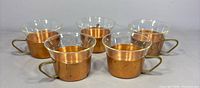Five assembled teacups showing glass inserts seated in copper holders