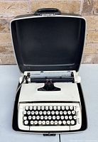 Typewriter seated in open hard case showing overall condition