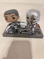 Front view of Finn and Captain Phasma Funko Pop! Moment diorama on base