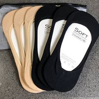 Front view showing beige and black no-show socks layered, inner cardboard inserts visible