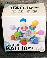 Front of boxed teether ball showing product image and age rating