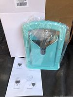 Bagel slicer sealed in plastic next to plain white box