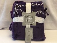 Folded purple fleece pajama set with tags and ribbon