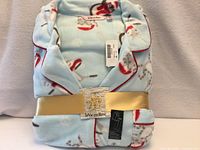 Folded pajama set with packaging showing brand and gold wrap