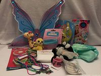 Group shot showing all items including wings, plushes, packaged toys, cords and wristbands