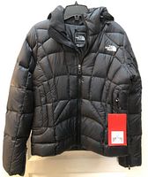 Front view of black The North Face down coat with tag attached