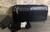 Front view of wallet purse with tag and coiled strap