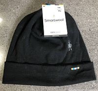 Full view of black Smartwool cuffed beanie with tags attached