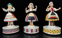 Front view of three Schmid Girls of the World music boxes