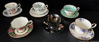 Group shot of all five cup-saucer sets and trio