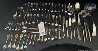 Full view of approximately 60 souvenir spoons, additional flatware, pens and shakers