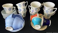 Multiple stacks of Portmeirion, Shelley and Aynsley cup and saucer sets grouped by pattern and colour