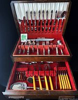 Open wooden flatware chest showing First Love flatware in lid and drawer contents