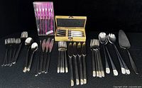 Entire lot displayed including IKEA cutlery sets, Laguiole spreaders, Spring cocktail forks, salad servers, cake server