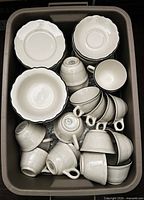 Bin containing stacked cups, saucers, side plates, cereal bowls
