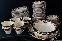 Stacked view of entire 92-piece Windsor Derby service showing plates, bowls, cups, saucers, and platters