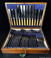 Open oak box showing full cutlery set in slots