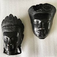 Both brass wall hanging masks side by side