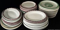 Three stacks of round dinner and luncheon plates with assorted rim designs