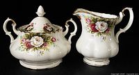 Front view of covered sugar bowl and cream jug