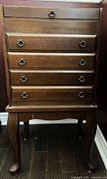 Front view showing four drawers, legs, hardware