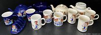 Group shot displaying all four teapots, eight mugs and toast rack