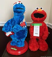 Front view of Cookie Monster and Elmo plush toys