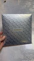Front of sealed Burberry towel package with TB monogram design and Burberry logo