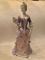 Front view of Hollohaza porcelain lady figurine showing colours, mirror, dress details