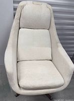 Full view of cream upholstered swivel chair