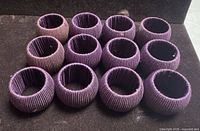 Front view of twelve purple cord-wrapped napkin rings