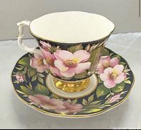 Teacup on saucer showing floral pattern and gold accents