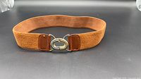 Full view of rust elastic belt with buckle fastened