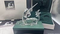 Crystal unicorn on green stand inside open inner box