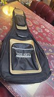 Full view of black and tan acoustic guitar gig bag on table