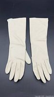 Pair of off-white leather gloves laid flat