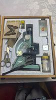 Open case showing microscope and accessories neatly set in foam