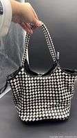 Front view of woven black-white leather shoulder bag