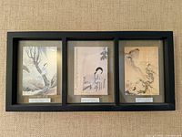 Full view of framed triptych showing three Chinese art prints in black frame