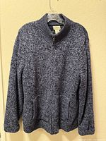 Full front view of blue marled lambswool full-zip sweater showing overall condition, collar, pockets and ribbed trim.