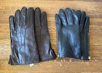 Brown and black pairs of leather gloves laid flat