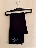 Full view of scarf hanging on hanger showing overall length and embroidered logo