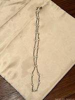 Full view of silver-tone chain necklace with pearls laid flat