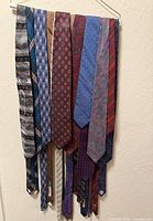 Fifteen assorted silk neckties hanging to show full length and patterns