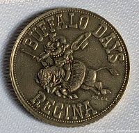Obverse of brass token showing rider on buffalo with legend Buffalo Days Regina