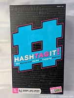 Front of HashTag It! game box showing graphics and age rating