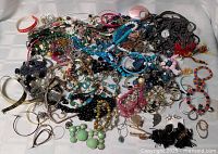 Full view of large mixed jewelry pile on white cloth
